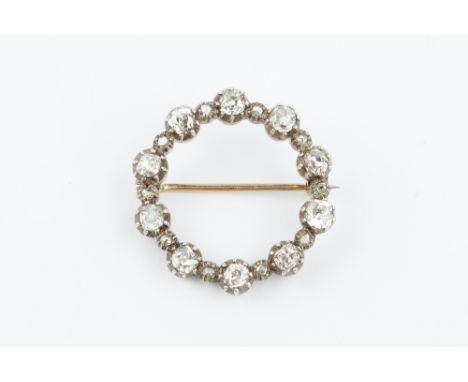 A DIAMOND CIRCLET BROOCH, designed as a row of cushion-shaped old-cut diamonds in pinched collet settings, spaced by similarl