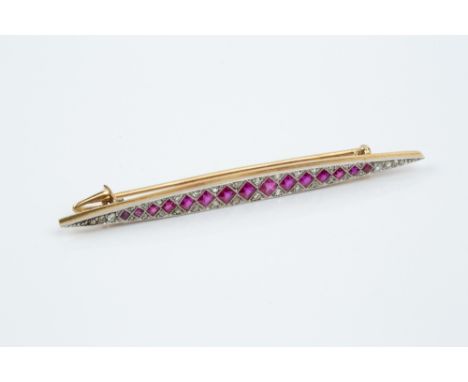A SYNTHETIC RUBY AND DIAMOND PANEL BROOCH, the elongated navette-shaped panel millegrain set with a line of graduated square 