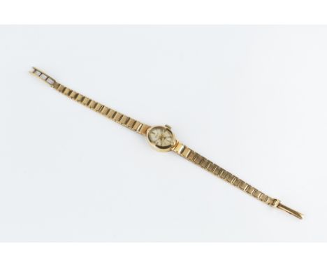 A LADY'S 9CT GOLD BRACELET WATCH BY ACCURIST, the oval silvered dial with baton markers and gilt tapered hands, to a jewelled