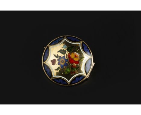AN ENAMEL PANEL BROOCH, the circular convex panel decorated with a spray of polychrome enamel flowerheads, within a blue and 