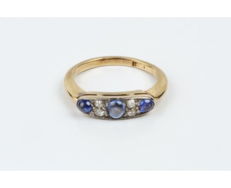 A SAPPHIRE AND DIAMOND HALF HOOP RING, millegrain set with a trio of oval and circular cabochon sapphires, spaced by pairs of