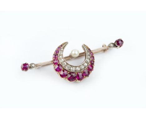 A LATE VICTORIAN/EDWARDIAN RUBY, DIAMOND AND PEARL CRESCENT BAR BROOCH, centred with a crescent of graduated oval mixed-cut r