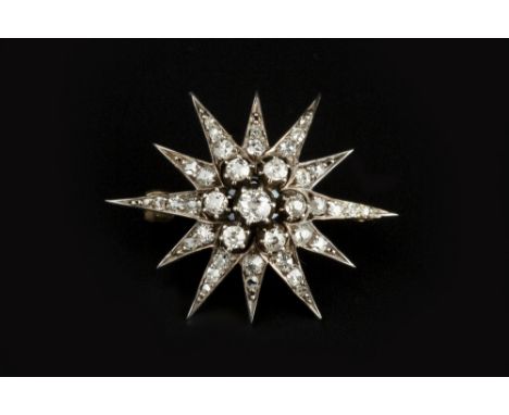 A DIAMOND STAR BROOCH, centred with a tiered cluster of old-cut diamonds, bordered by rays of smaller old, single and lasque-