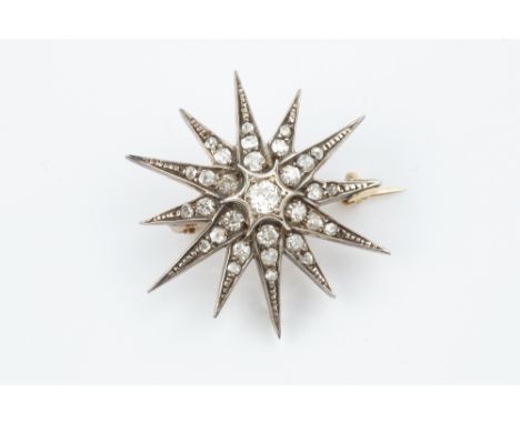 A DIAMOND STAR BROOCH, the principal old-cut diamond bordered by graduated old, single and rose-cut diamond set rays, two col