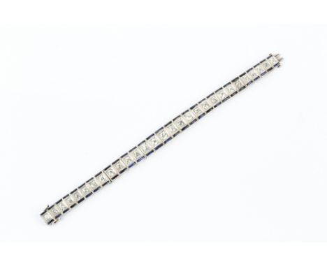 AN ART DECO DIAMOND AND GEM SET BRACELET, designed as a tapered line of articulated rectangular panels, each millegrain set w