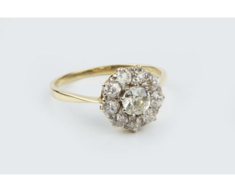 A DIAMOND CLUSTER RING, the principal old-cut diamond claw set within a border of smaller similarly cut diamonds, two colour 