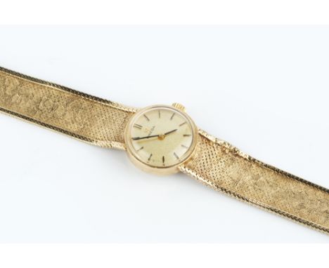 A LADY'S 9CT GOLD BRACELET WATCH BY OMEGA, the circular gilt dial with baton markers, to a calibre 484 jewelled manual moveme