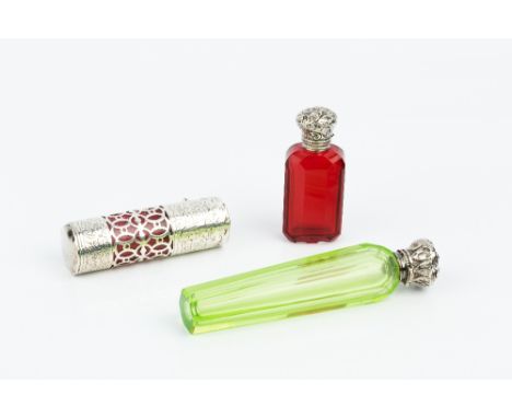 AN EDWARDIAN SILVER CYLINDRICAL SCENT BOTTLE, engraved with scrolling foliage and having pierce decorated band with cranberry