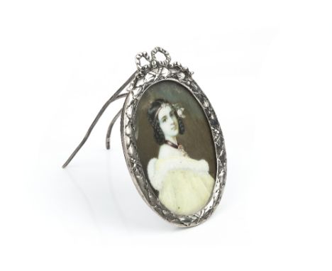 AN EARLY 20TH CENTURY CONTINENTAL SILVER OVAL EASEL FRAME, with pierced ribbon cresting, containing an oval portrait miniatur