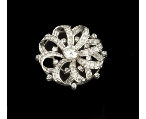 A DIAMOND PANEL BROOCH, of whorl design, centred with a round brilliant-cut diamond in eight claw setting, enclosed by bands 