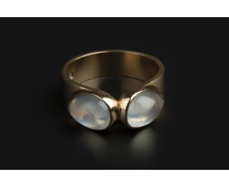 A MOONSTONE DRESS RING, centred with two pear-shaped cabochon moonstones in collet settings, 9ct gold mounted, ring size N (l