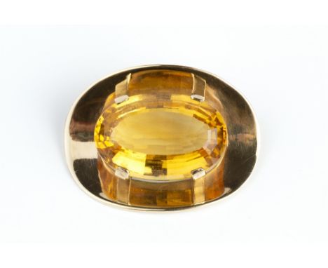 A CITRINE SINGLE STONE BROOCH, the oval mixed-cut citrine in four claw setting, to a concave oval mount stamped '9ct', length