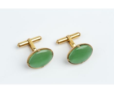 A PAIR OF JADE CUFFLINKS, each oval jadeite cabochon claw set within a reeded surround, on hinged baton fittings, yellow prec
