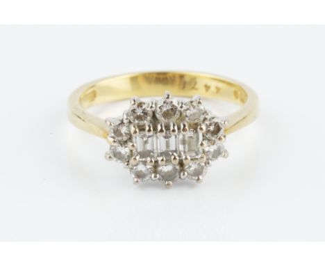 A DIAMOND CLUSTER RING, centred with a trio of rectangular step-cut diamonds, bordered by round brilliant-cut diamonds in cla