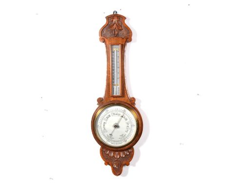 Oak aneroid barometer, circular silvered dial, thermometer over, case with carved decoration, 82cm.