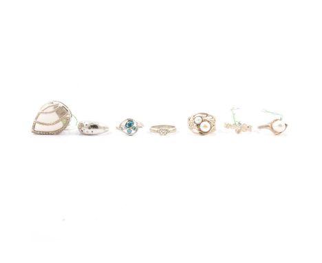 A synthetic white and black gemset ring, the ten small stones flush set into the top of a tapering shank, in white metal mark