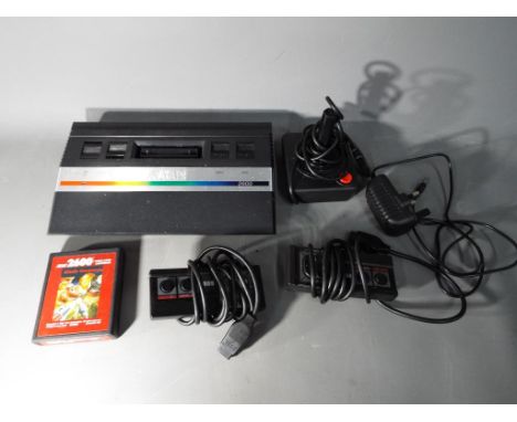 Atari - An unboxed Atari 2600 games console with two control pads, joystick and unboxed Missile Command game cartridge.