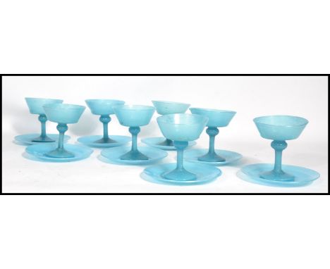 A set of eight vintage 20th century blue glass champagne / dessert glasses and saucers. Raised on circular bases with knopped