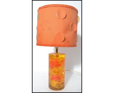 A retro vintage mid 20th century Shatterline amber type resin lamp base in orange having a cylindrical shade atop. 40cm.