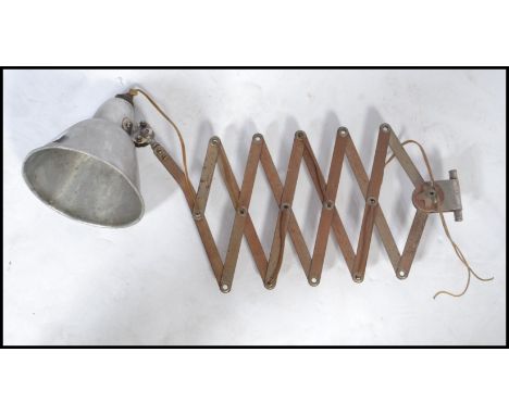 A vintage 20th century Industrial french polished steel lamp being wall mounted attached to an extending scissor action arm. 
