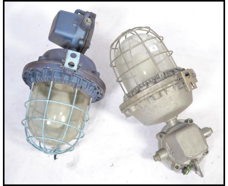 A good pair of Industrial heavy extreme condition drop pendant bulkhead lights of large form with caged bulbs and notation to