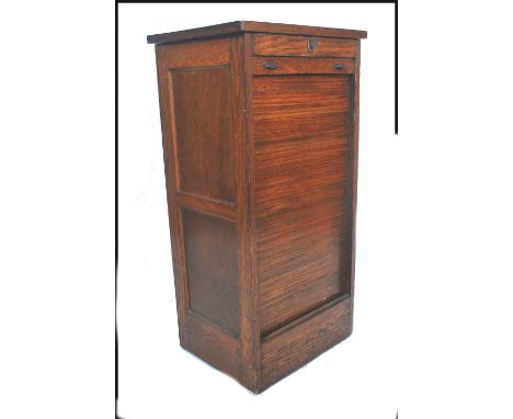 An early 20th century tambour fronted filing cabinet having a locking front that slides down to reveal a good quantity of sli