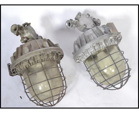 A good pair of Industrial heavy extreme condition drop pendant bulkhead lights of large form with caged bulbs and notation to