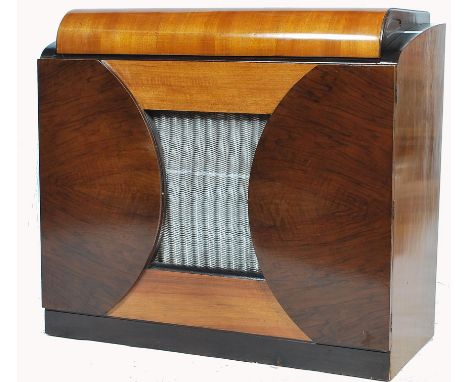 A stunning mid 20th century Defiant radiogram, speaker grill too the centre of the cabinet, lift up lid revealing a Defiant r