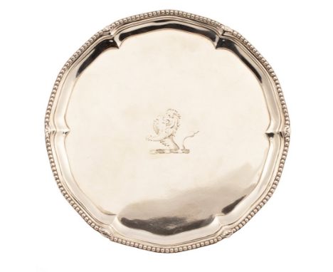 A George III silver waiter, IC, London 1774, the pie crust border and beaded rim on three claw and ball feet, crested, 18cm d