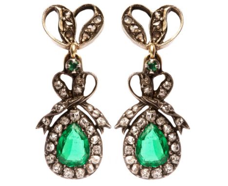 A pair of early 19th Century diamond and emerald earrings, the pear-shaped emerald and diamond clusters each beneath a ribbon