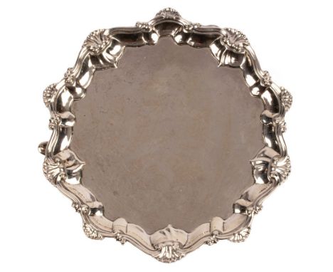 A George II silver card waiter, Richard Rugg, London, 1759, with piecrust and shell border on three hoofed feet, 16.5cm diame