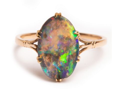 An Edwardian black opal ring, the oval flat topped opal approximately 13mm x 8.8mm x 3.4mm, claw set, size R, stamped 15ct, t