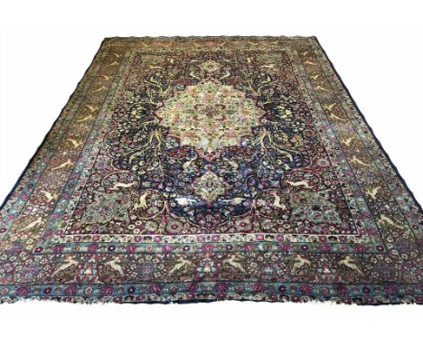 KIRMAN CARPET, 373cm x 265cm, central medallion on a midnight blue flower head and bird field within ruby spandrels and compl