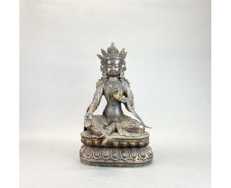 A large Tibetan bronze figure of a seated crowned Buddha, H. 48cm.