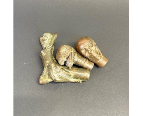 A group of three bronze walking stick handles, largest 11 x 9cm.