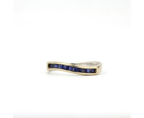A white metal ring set with princess cut sapphires, (L).