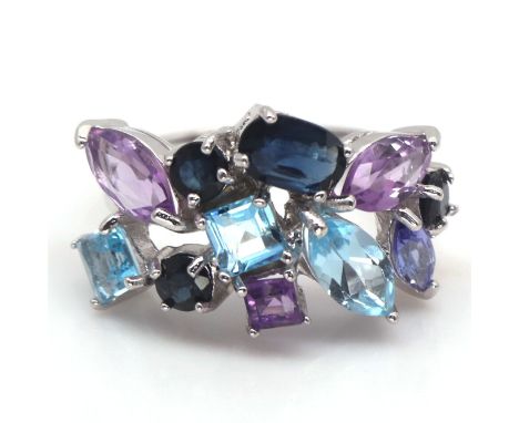 A 925 silver ring set with amethysts, blue topaz and sapphires, ring size L.
