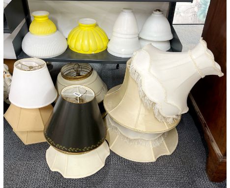 A large collection of glass , metal and other lamp shades.
