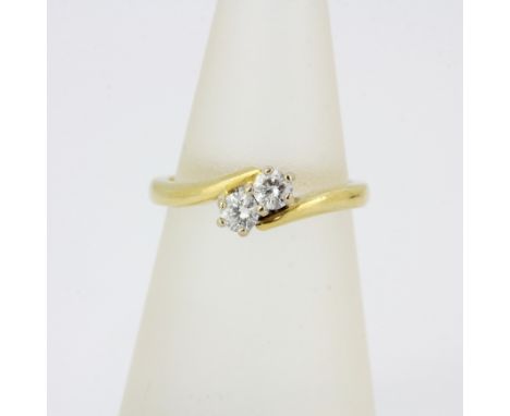A hallmarked 18ct yellow gold diamond set crossover ring, approx. 0.20ct total, (K.5), gross weight approx. 3.5gr.&nbsp;