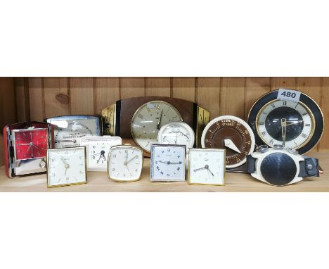 A group of vintage clocks, with a cream Bakelite thermometer.