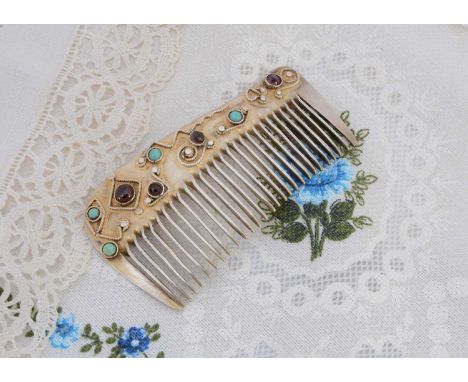 An Arts and Crafts mixed metal hair comb, having turquoise and red stones set in relief collet settings, 8.5cm x 4.5cm