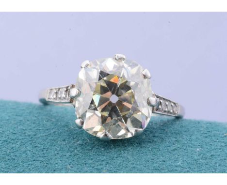 An old cushion cut diamond solitaire ring, the platinum ring supporting a cushion cut, claw set diamond with diamond set shou