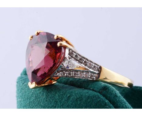An 18ct gold Lorique rubellite and diamond set dress ring, the pear shaped rubellite in three claw setting on ornate diamond 