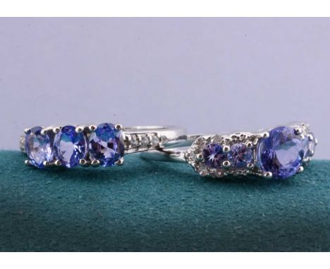 Two white 9ct gold tanzanite dress rings, one three stone example with gem set shoulders and a dress ring, both ring size N, 