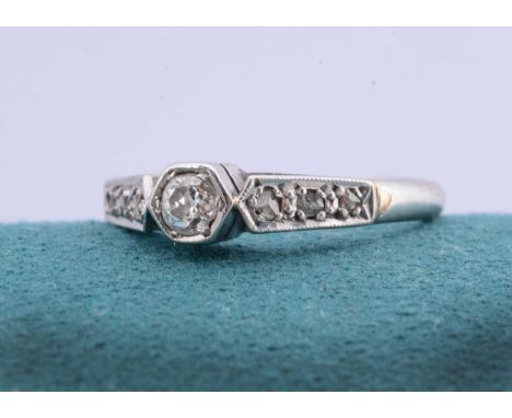 An art deco platinum diamond dress ring, the old cut diamond in hexagonal setting with diamond chip set shoulders, ring size 