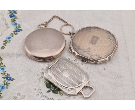 An art deco silver rectangular compact, having engine turned design, oval hinged lidded section with fixed loop handle Birmin