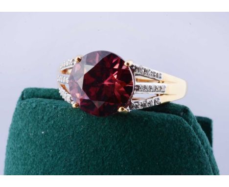 An 18ct gold Lorique red zircon and diamond set dress ring, the Zanzibar zircon in four claw setting flanked by a trident of 