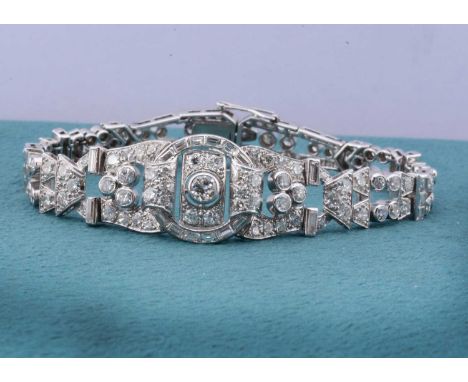 An art deco platinum set diamond bracelet of architectural pierced design, with tongue and box clasp and two bracket safety c