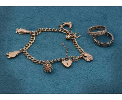 A 9ct gold charm bracelet set with various novelty and comical charms, including Puff the Magic Dragon, Paddington Bear, Hedg