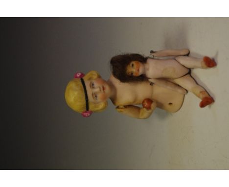 A bisque pin cushion doll stamped 467 Germany circa 1920; an articulated bisque miniature doll circa 1900. (2)